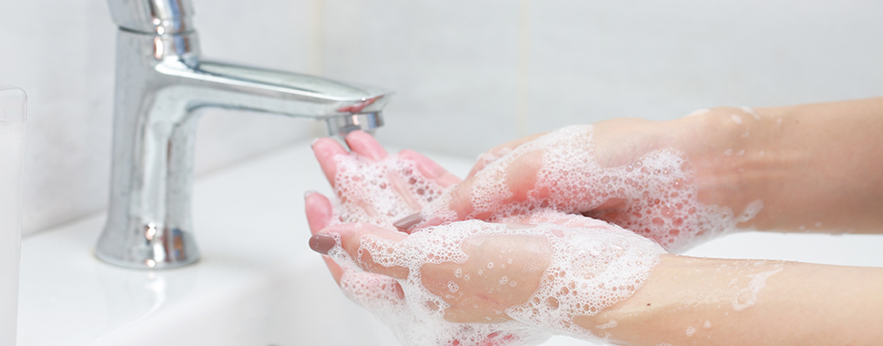 Kvinnliga händer som tvättas med tvål för god handhygien.
